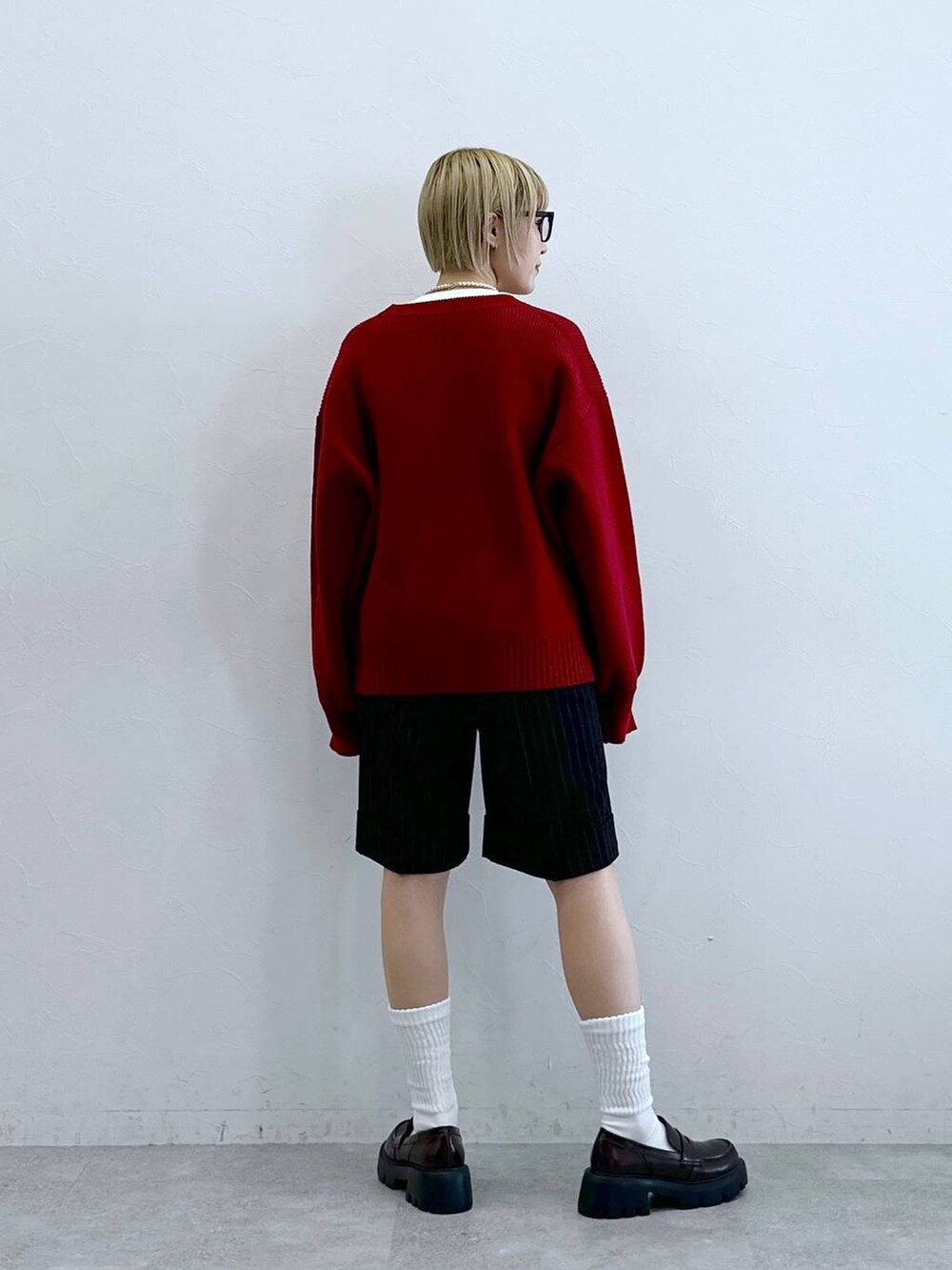 ブラック系のローファー、ブラック系のスラックス、レッド系のニット/セーターを着用したレディースの秋コーディネートの7枚目の写真