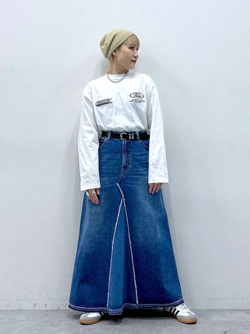 ブルー系のデニムスカート、ホワイト系のTシャツ/カットソー、ベージュ系のハンチング/ベレー帽を着用したレディースの冬コーディネートの5枚目の写真