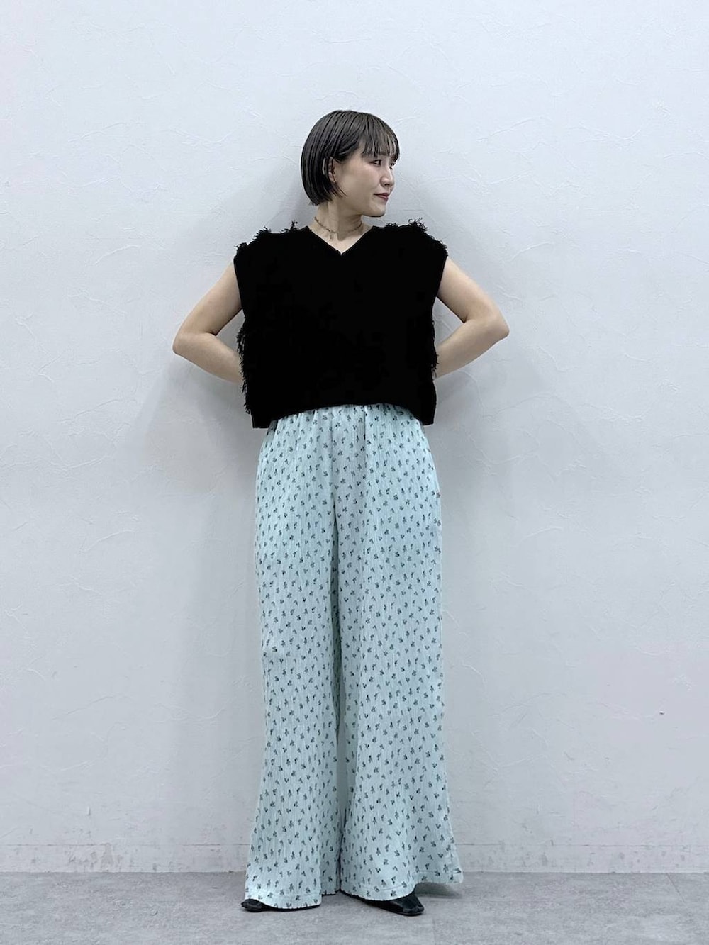 ブルー系のスラックス、ブラック系のベストを着用したレディースの春コーディネートの2枚目の写真