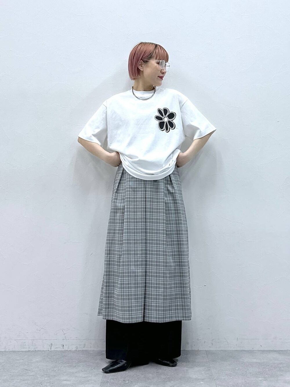 グレー系のワンピース、ホワイト系のTシャツ/カットソー、ブラック系のスラックスを着用したレディースの春コーディネートの3枚目の写真