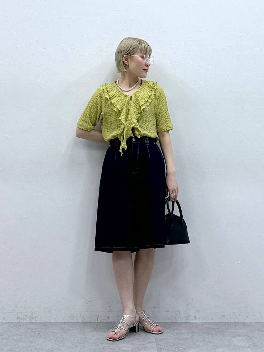 イエロー系のシャツ/ブラウス、ブルー系のデニムパンツ、ブラック系のメガネを着用したレディースの夏コーディネートの5枚目の写真