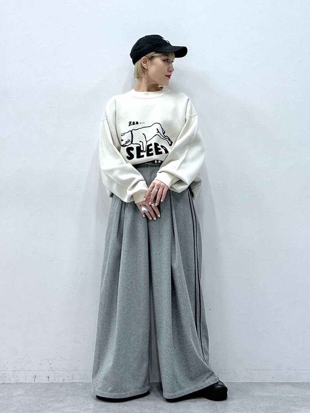 ブラック系のスラックス、ホワイト系のニット/セーターを着用したレディースの冬コーディネートの2枚目の写真