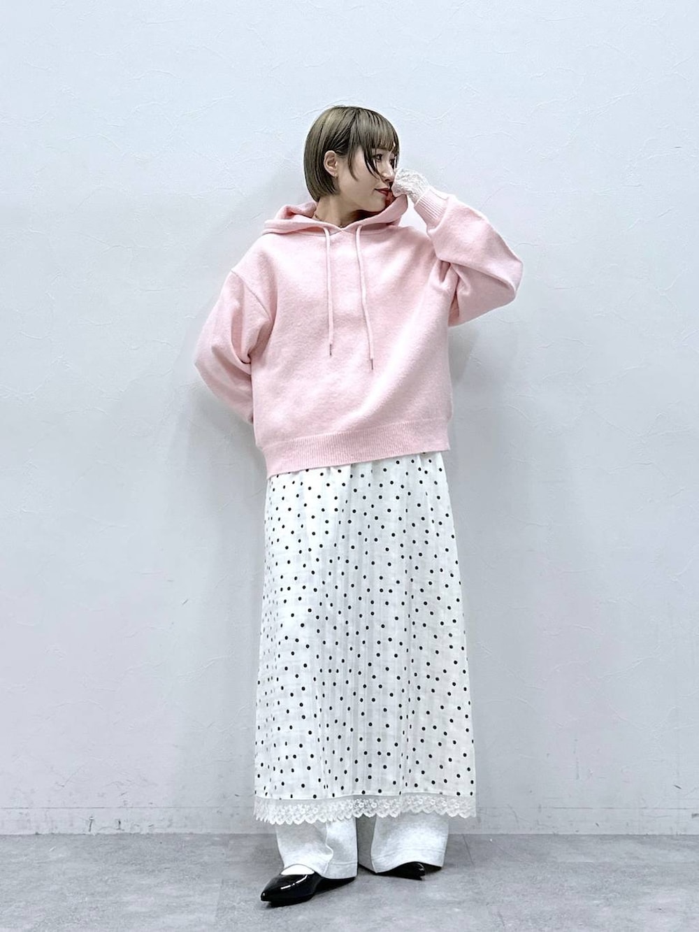 ホワイト系のTシャツ/カットソー、ブラック系のパンプス、ピンク系のニット/セーターを着用したレディースの冬コーディネートの2枚目の写真