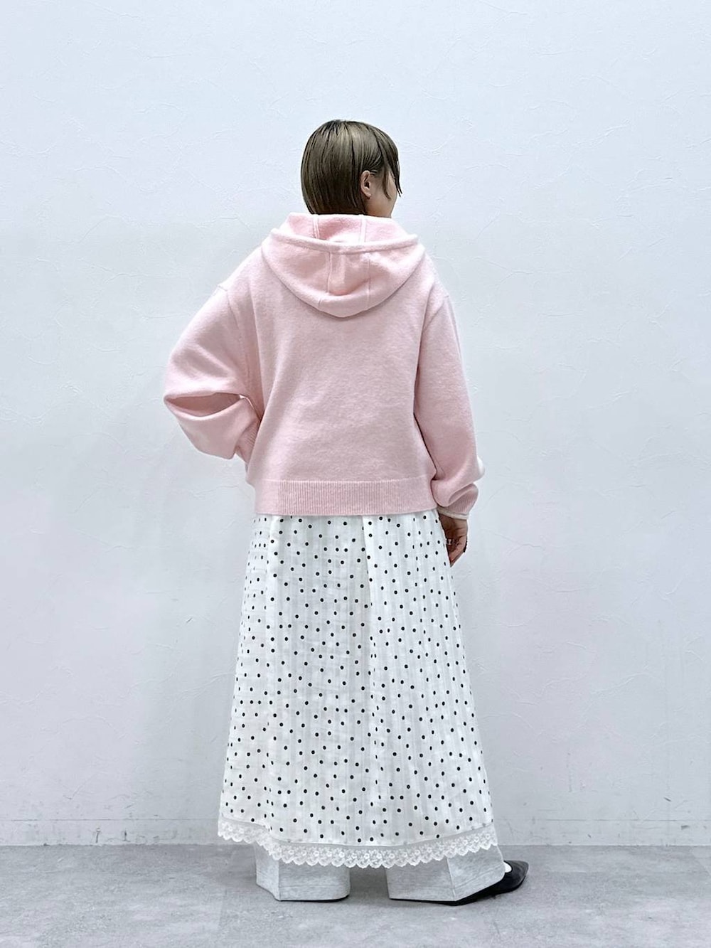 ホワイト系のTシャツ/カットソー、ブラック系のパンプス、ピンク系のニット/セーターを着用したレディースの冬コーディネートの5枚目の写真