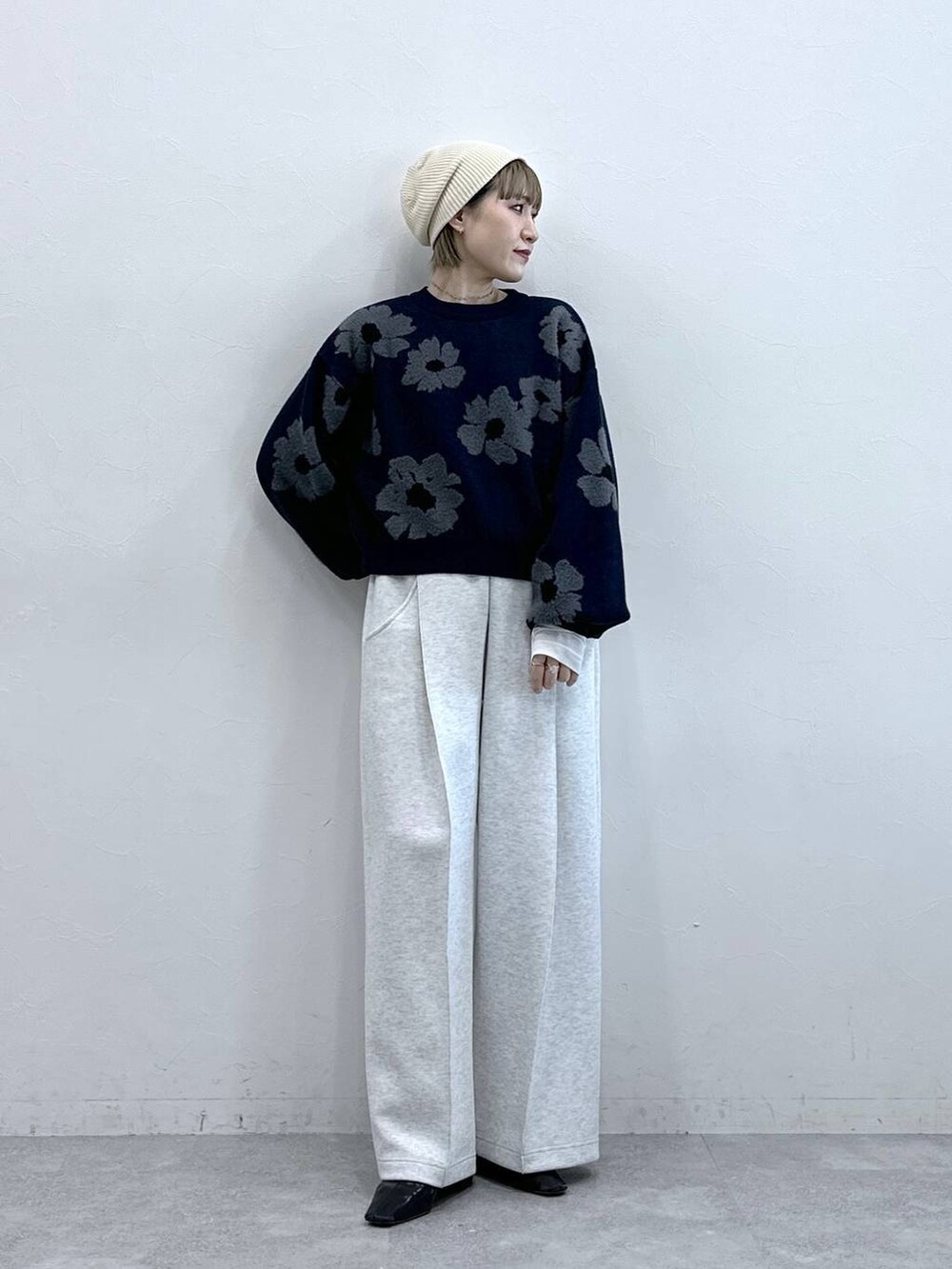 ホワイト系のスウェットパンツ、ブルー系のニット/セーター、ホワイト系のTシャツ/カットソーを着用したレディースの冬コーディネートの3枚目の写真