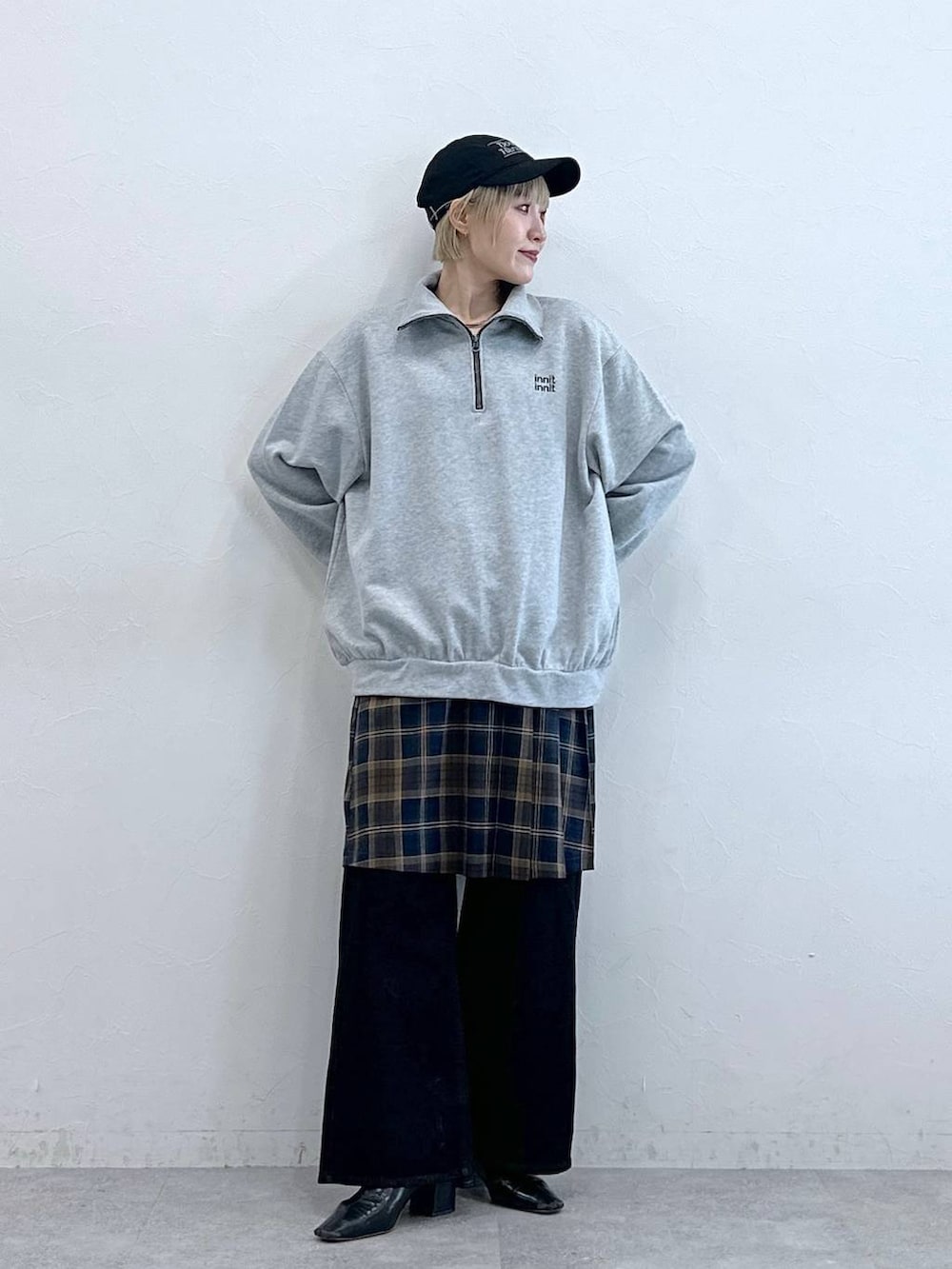 ブラック系のデニムパンツ、グレー系のスウェット、ブラウン系のスカートを着用したレディースの秋コーディネートの2枚目の写真