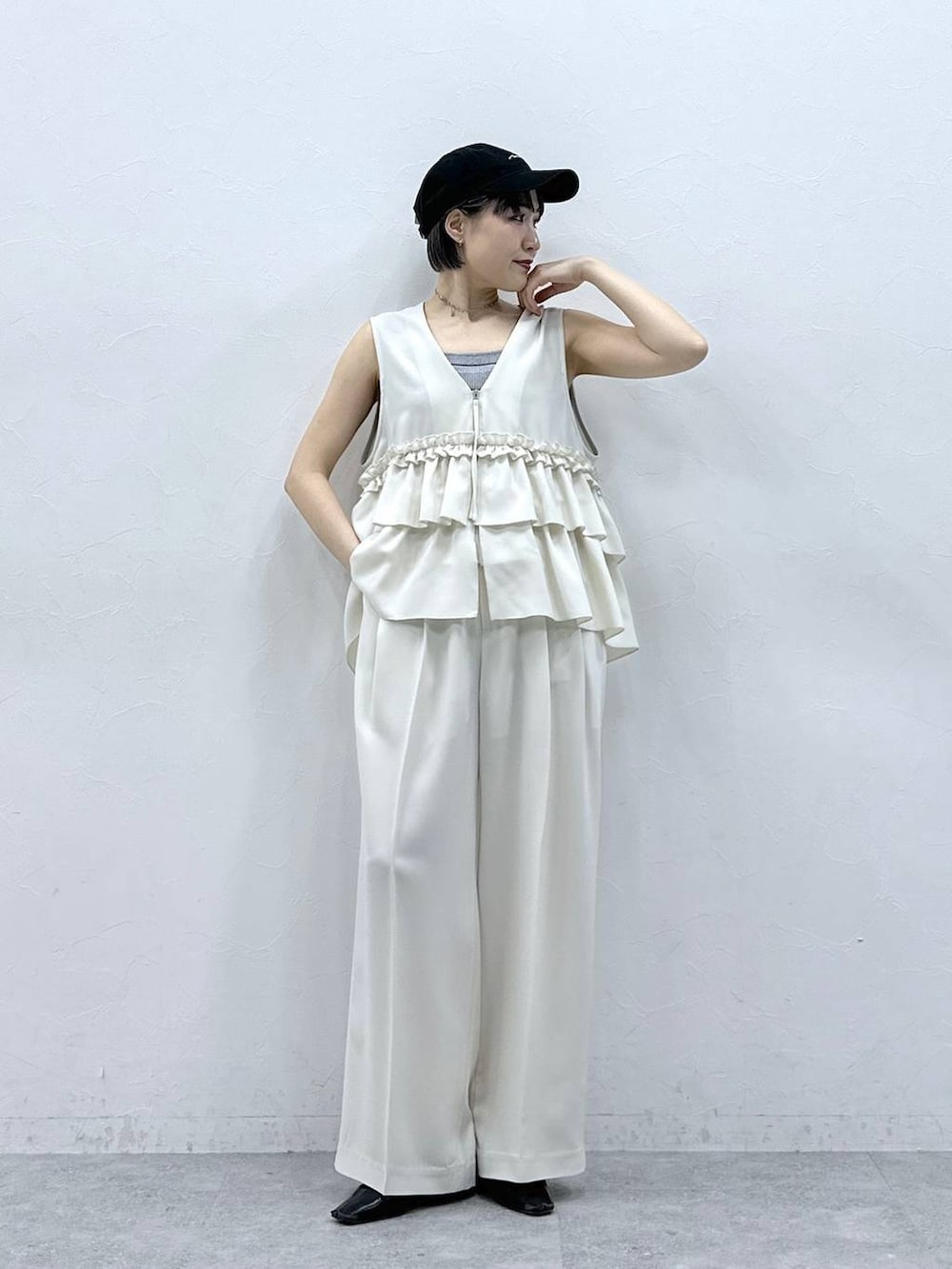 グレー系のタンクトップ、ブラック系のキャップを着用したレディースの春コーディネートの4枚目の写真