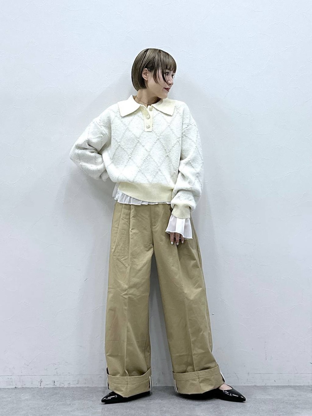 ブラック系のパンプス、ホワイト系のTシャツ/カットソー、ベージュ系のチノパンツを着用したレディースの冬コーディネートの4枚目の写真