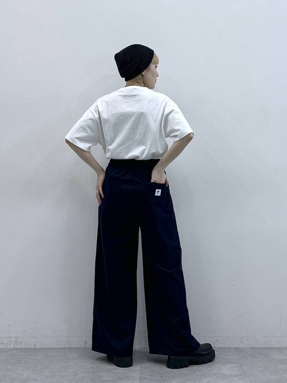 ブラック系のローファー、ホワイト系のTシャツ/カットソー、ブルー系のスラックスを着用したレディースの春コーディネートの6枚目の写真