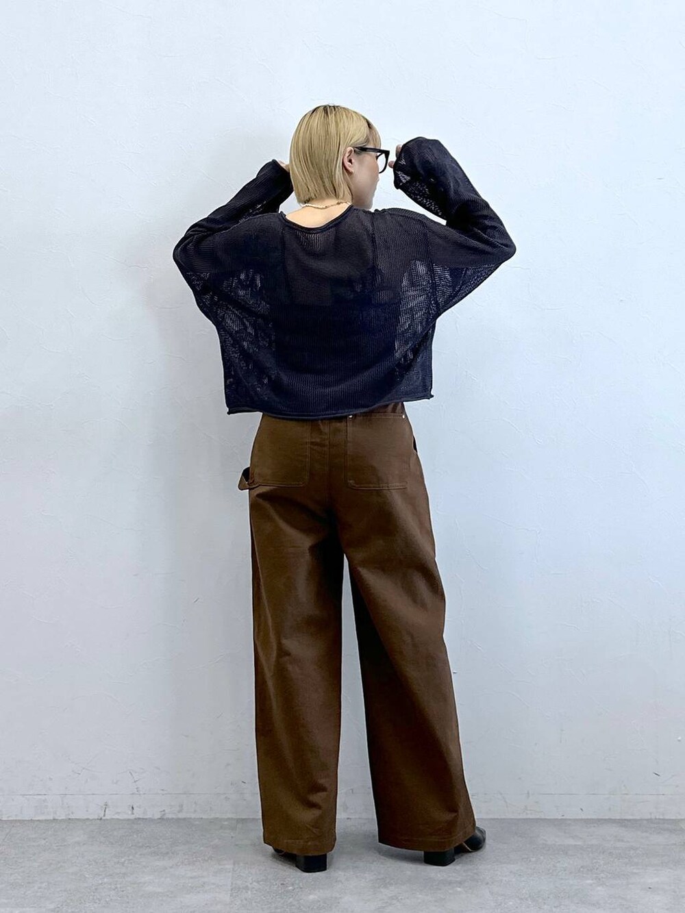 グレー系のニット/セーター、ブラウン系のチノパンツ、グレー系のメガネを着用したレディースの夏コーディネートの8枚目の写真