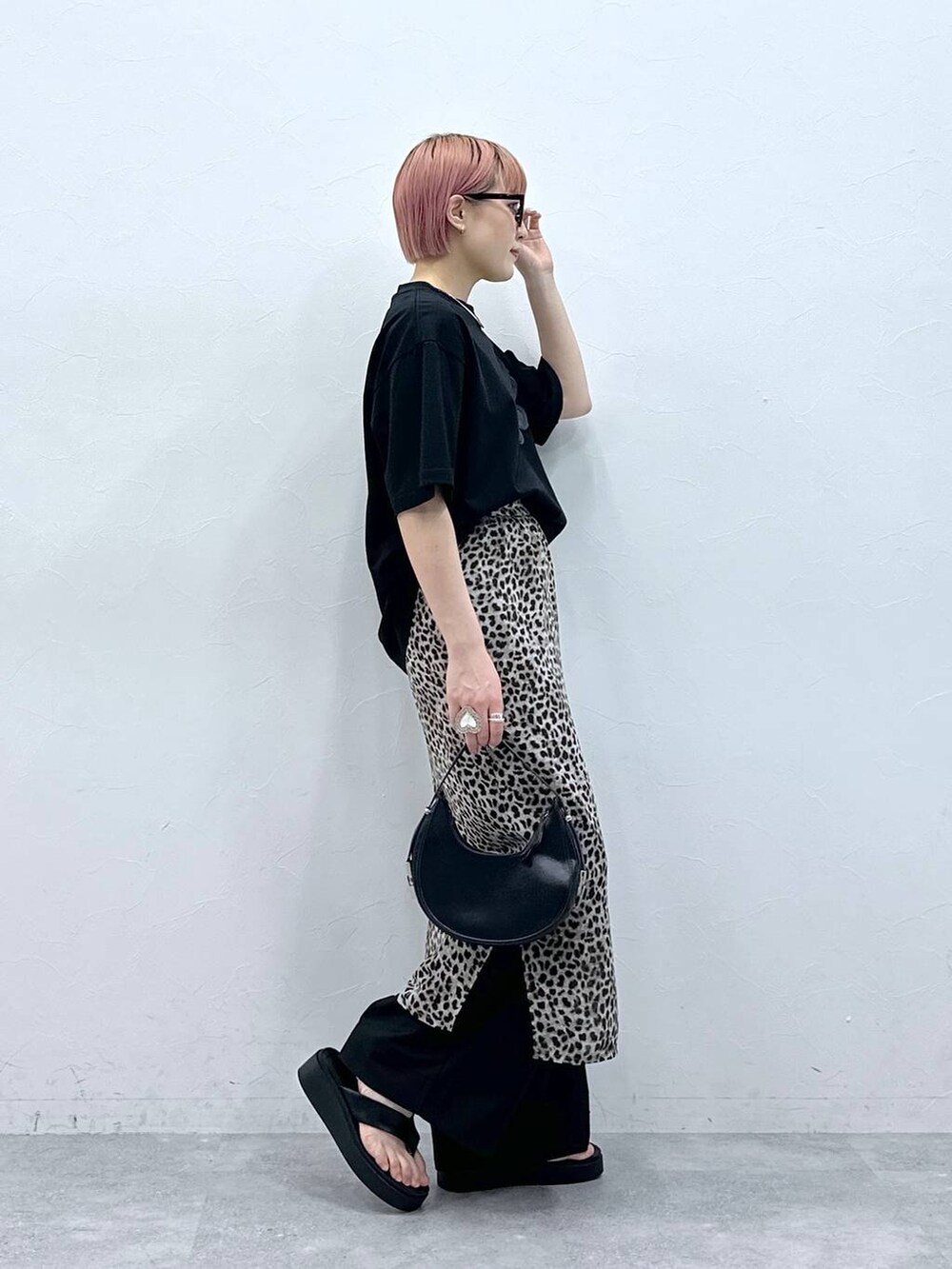 ブラック系のスラックス、ブラック系のTシャツ/カットソー、ベージュ系のスカートを着用したレディースの春コーディネートの4枚目の写真