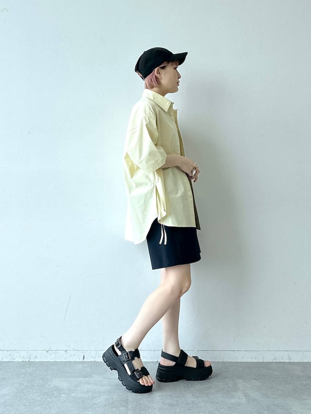 ブラック系のサンダル、ブルー系のスラックス、イエロー系のシャツ/ブラウスを着用したレディースの春コーディネートの4枚目の写真