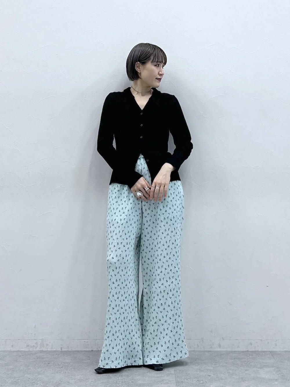 ブルー系のスラックス、ブラック系のカーディガン/ボレロを着用したレディースの春コーディネートの2枚目の写真