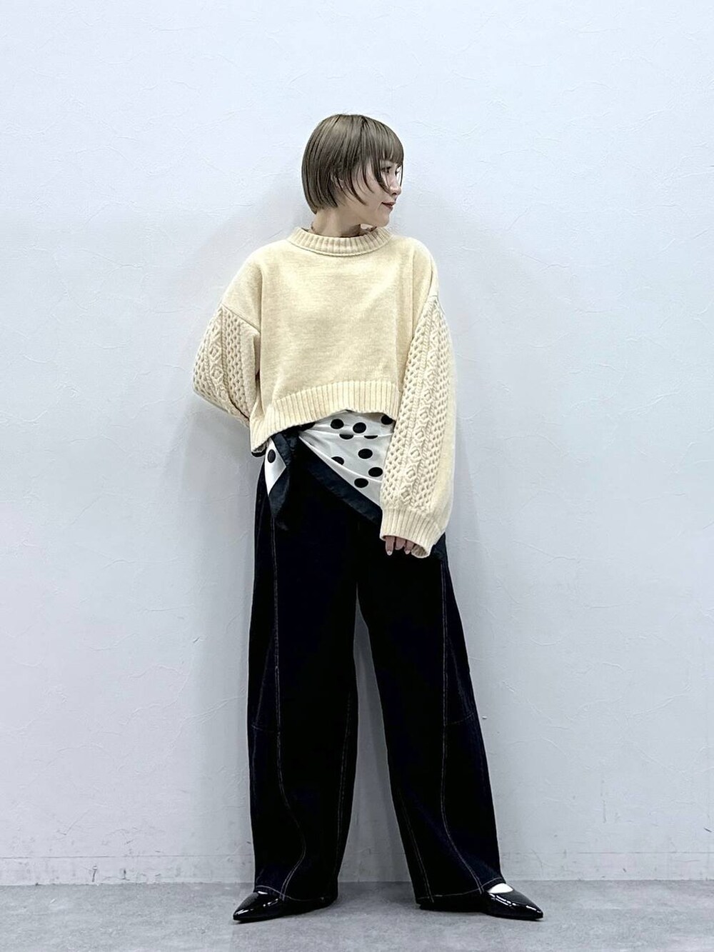 ホワイト系のニット/セーター、ブラック系のパンプス、ブラック系のデニムパンツを着用したレディースの冬コーディネートの3枚目の写真