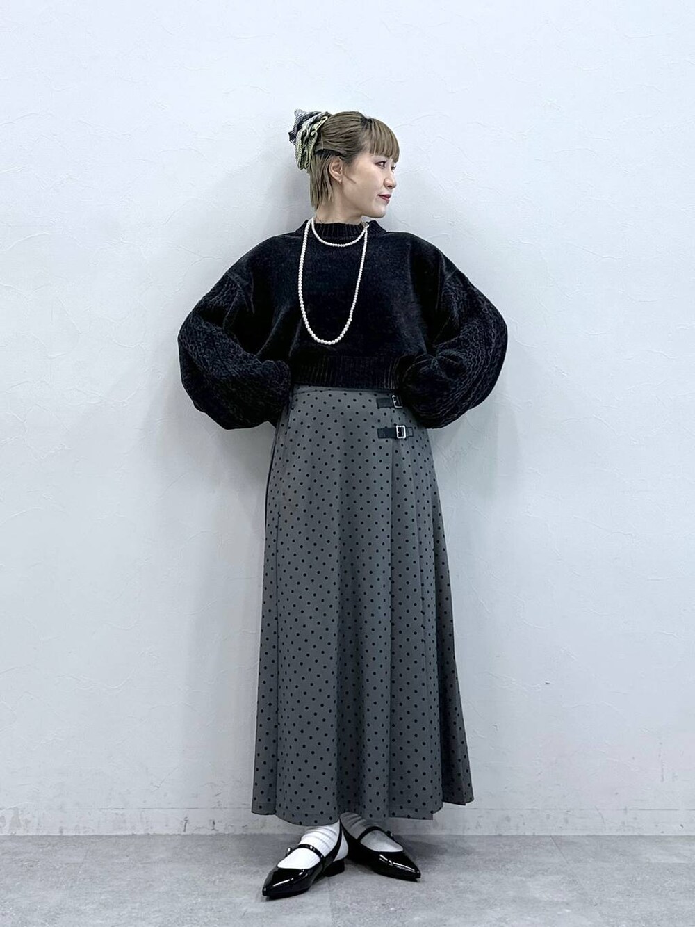 ブラック系のニット/セーター、ブラック系のパンプス、グレー系のスカートを着用したレディースの冬コーディネートの4枚目の写真