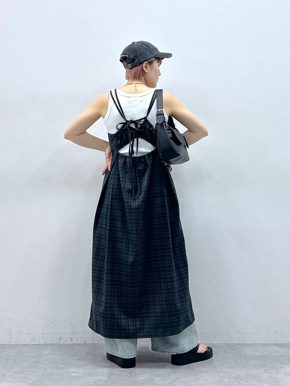 ブルー系のデニムパンツ、グレー系のワンピース、ホワイト系のタンクトップを着用したレディースの春コーディネートの5枚目の写真