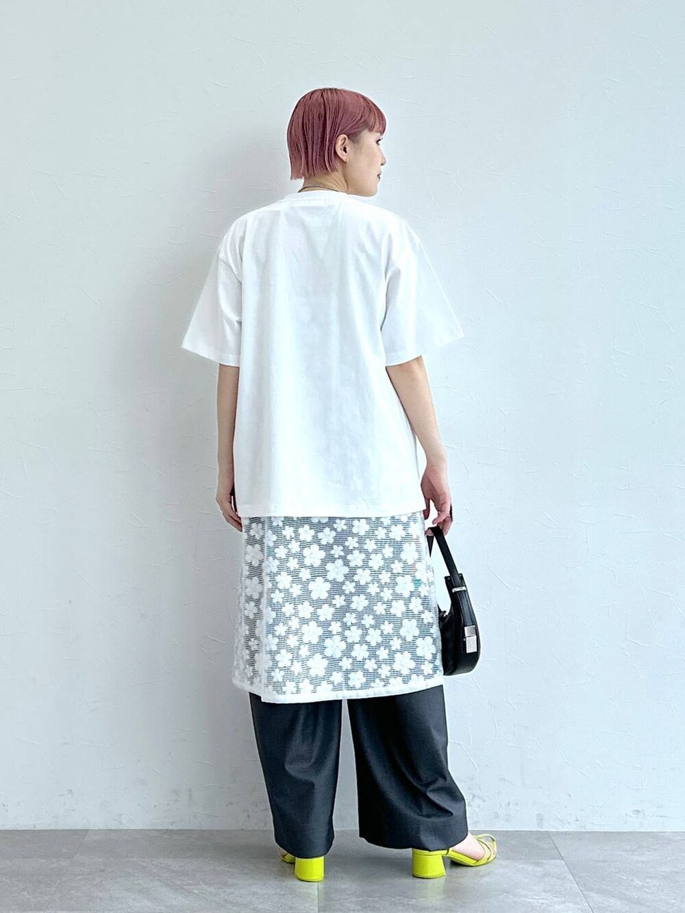 グレー系のスラックス、ホワイト系のワンピース、ホワイト系のTシャツ/カットソーを着用したレディースの春コーディネートの5枚目の写真