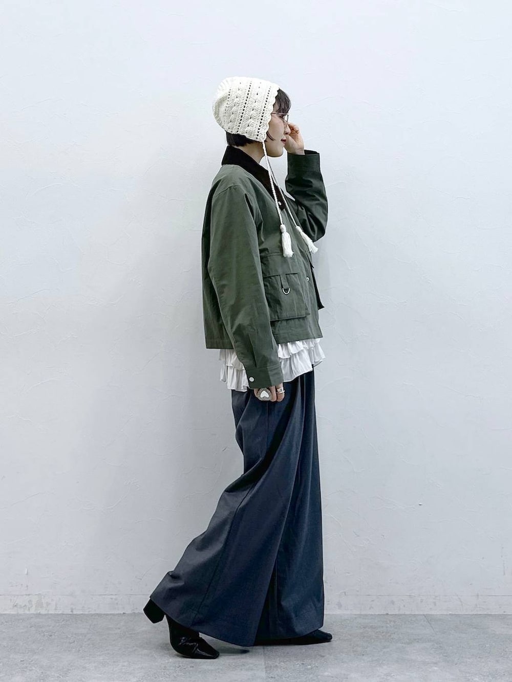 ホワイト系のキャミソール、グリーン系のブルゾン、グレー系のスラックスを着用したレディースの春コーディネートの5枚目の写真