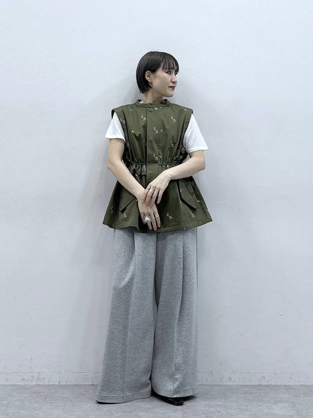 グレー系のスウェットパンツ、ホワイト系のTシャツ/カットソー、グリーン系のベストを着用したレディースの春コーディネートの2枚目の写真