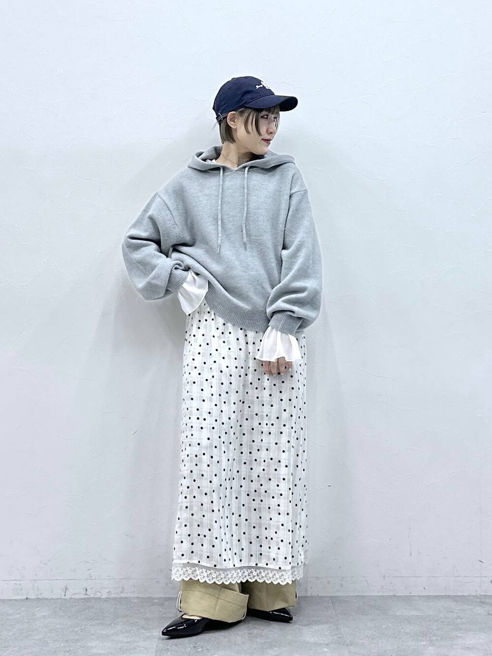 ブラック系のパンプス、グレー系のニット/セーター、ベージュ系のチノパンツを着用したレディースの冬コーディネートの3枚目の写真