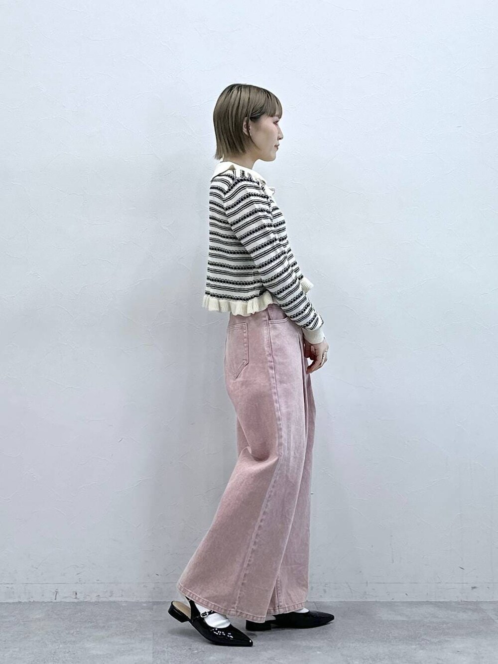 ブラック系のパンプス、ピンク系のデニムパンツ、ホワイト系のカーディガン/ボレロを着用したレディースの冬コーディネートの6枚目の写真