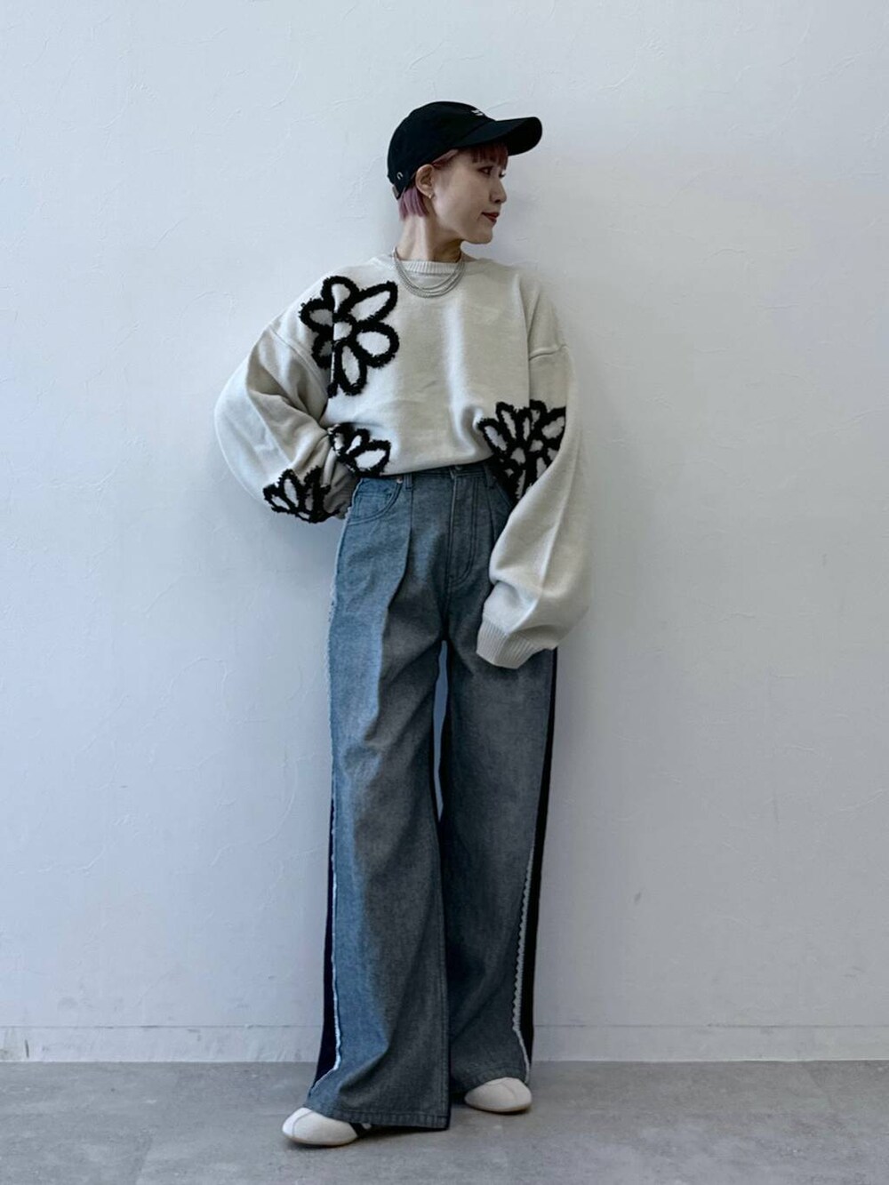 ホワイト系のニット/セーター、ブルー系のデニムパンツ、ホワイト系のスニーカーを着用したレディースの冬コーディネートの2枚目の写真