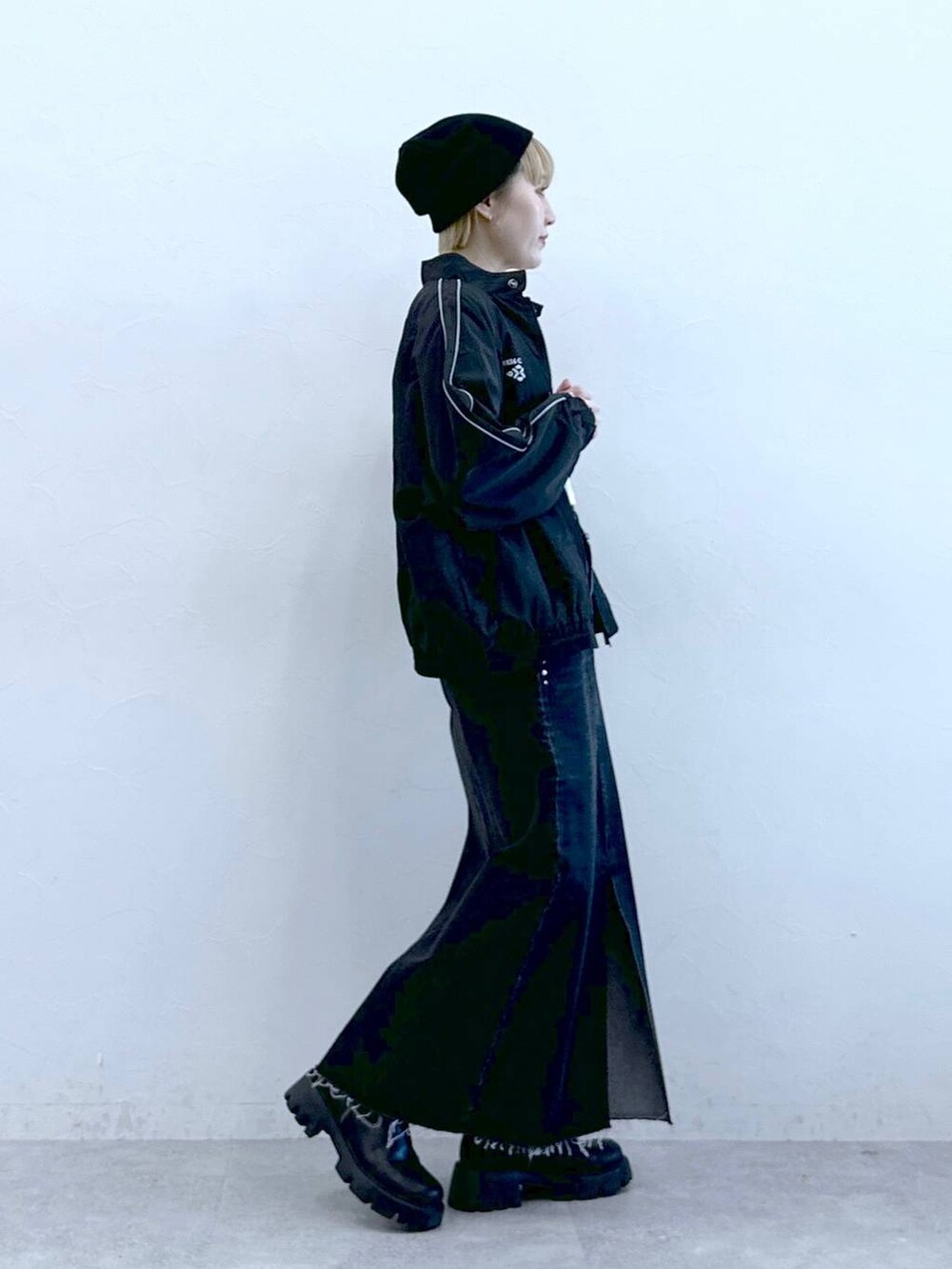 ブラック系のブーツ、ブラック系のデニムスカートを着用したレディースの冬コーディネートの3枚目の写真