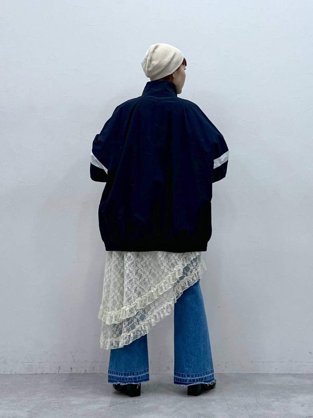 ブルー系のブルゾン、ブルー系のデニムパンツ、ホワイト系のスカートを着用したレディースの春コーディネートの5枚目の写真