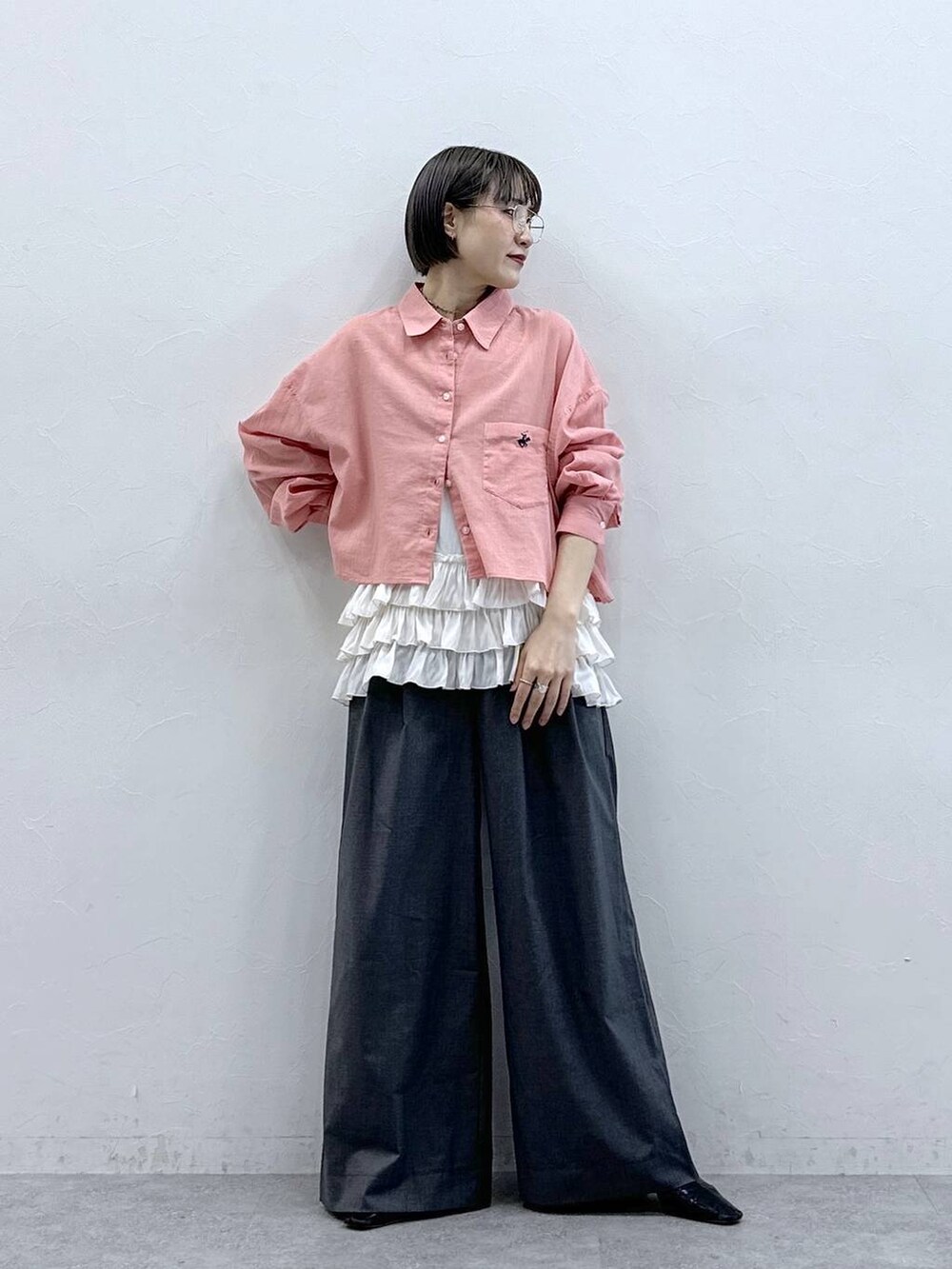 ホワイト系のキャミソール、ピンク系のシャツ/ブラウス、グレー系のスラックスを着用したレディースの春コーディネートの2枚目の写真