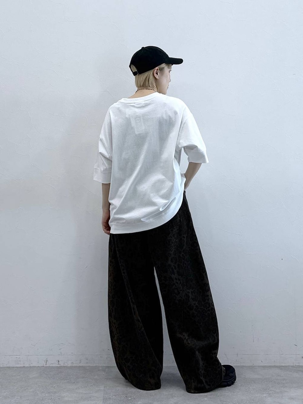 ホワイト系のTシャツ/カットソー、ブラック系のサンダル、ブラウン系のデニムパンツを着用したレディースの春コーディネートの5枚目の写真