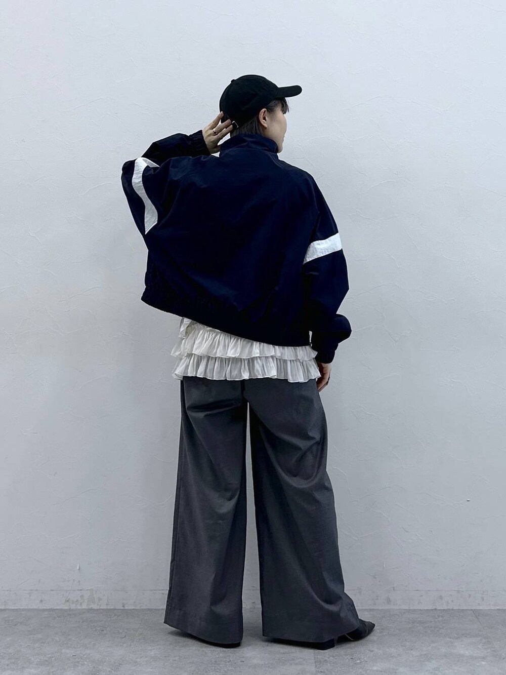 ホワイト系のキャミソール、ブルー系のブルゾン、グレー系のスラックスを着用したレディースの春コーディネートの7枚目の写真