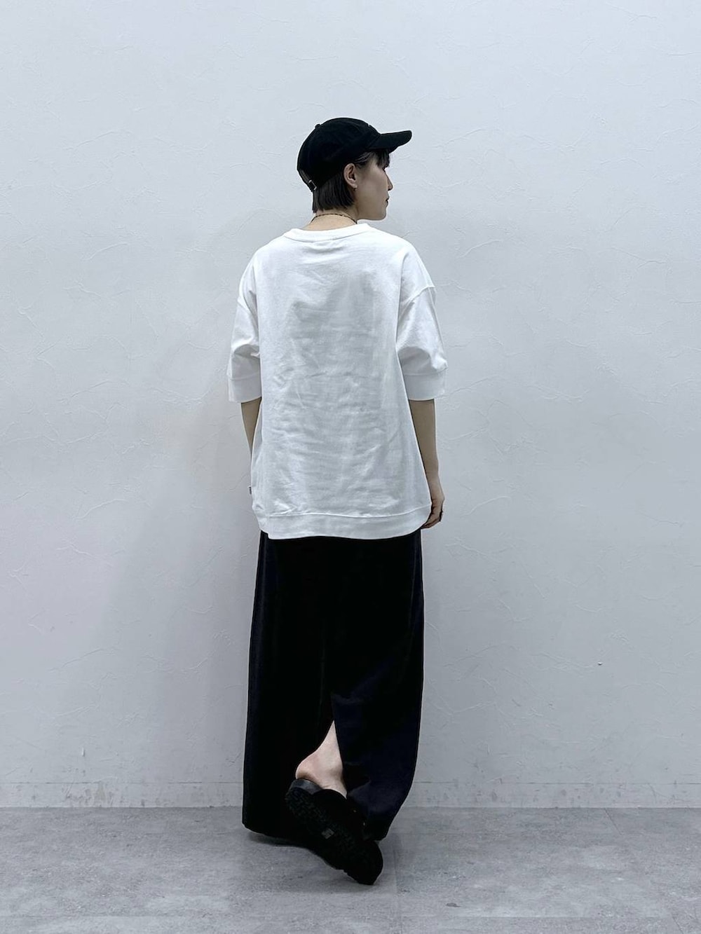 ホワイト系のTシャツ/カットソー、ブラック系のモカシン/デッキシューズ、ブラック系のスカートを着用したレディースの春コーディネートの5枚目の写真