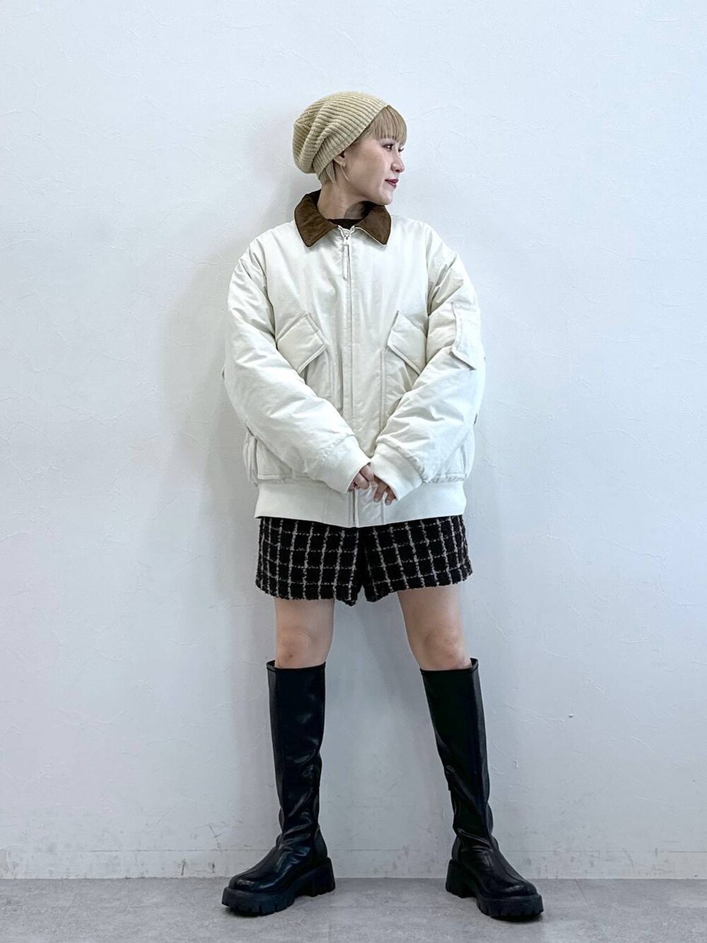 ブラック系のブーツ、ホワイト系のブルゾン、ブラウン系のその他パンツを着用したレディースの冬コーディネートの5枚目の写真