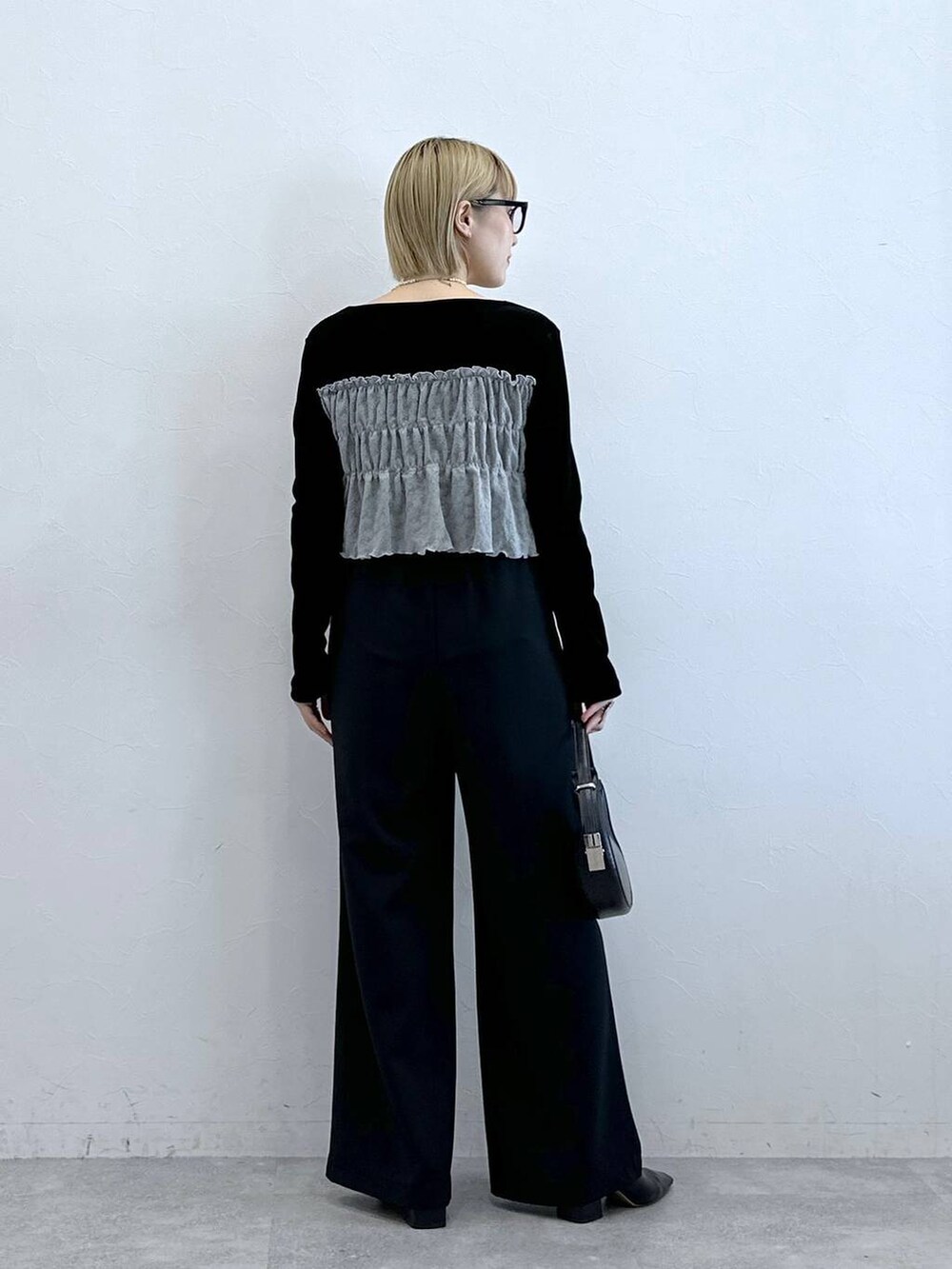 ブラック系のスラックス、ブラック系のTシャツ/カットソー、グレー系のメガネを着用したレディースの夏コーディネートの6枚目の写真