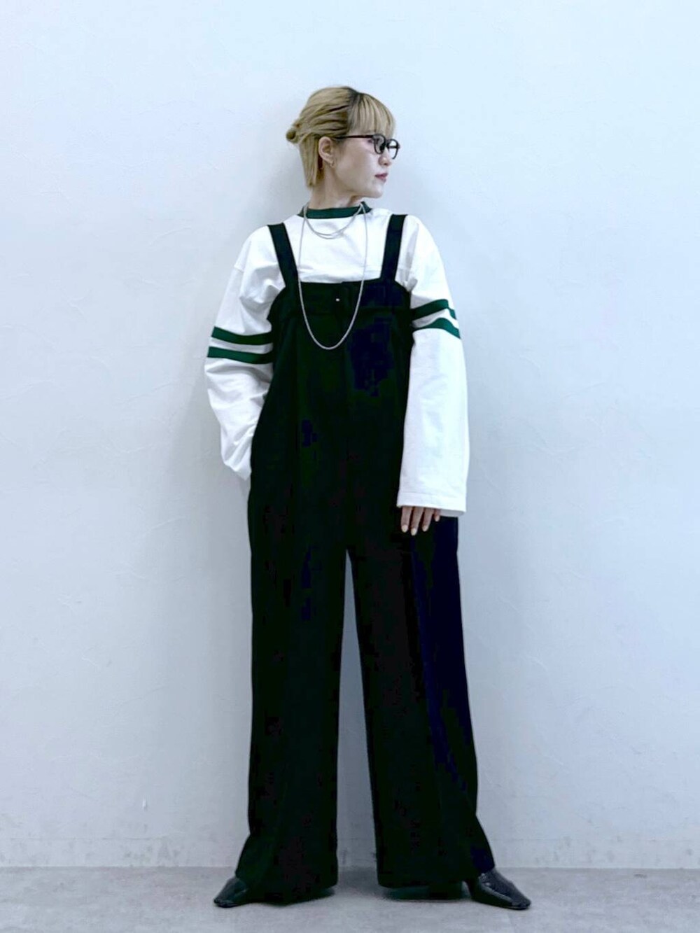 ブラック系のサロペット/オーバーオール、ホワイト系のTシャツ/カットソーを着用したレディースの冬コーディネートの3枚目の写真