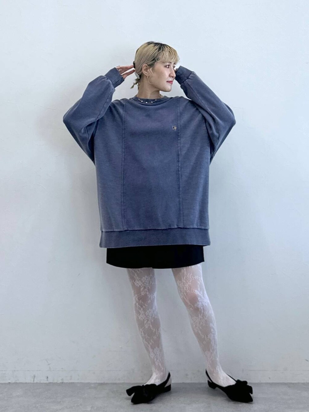 ブラック系のパンプス、ブラック系のチノパンツ、ブルー系のスウェットを着用したレディースの秋コーディネートの4枚目の写真