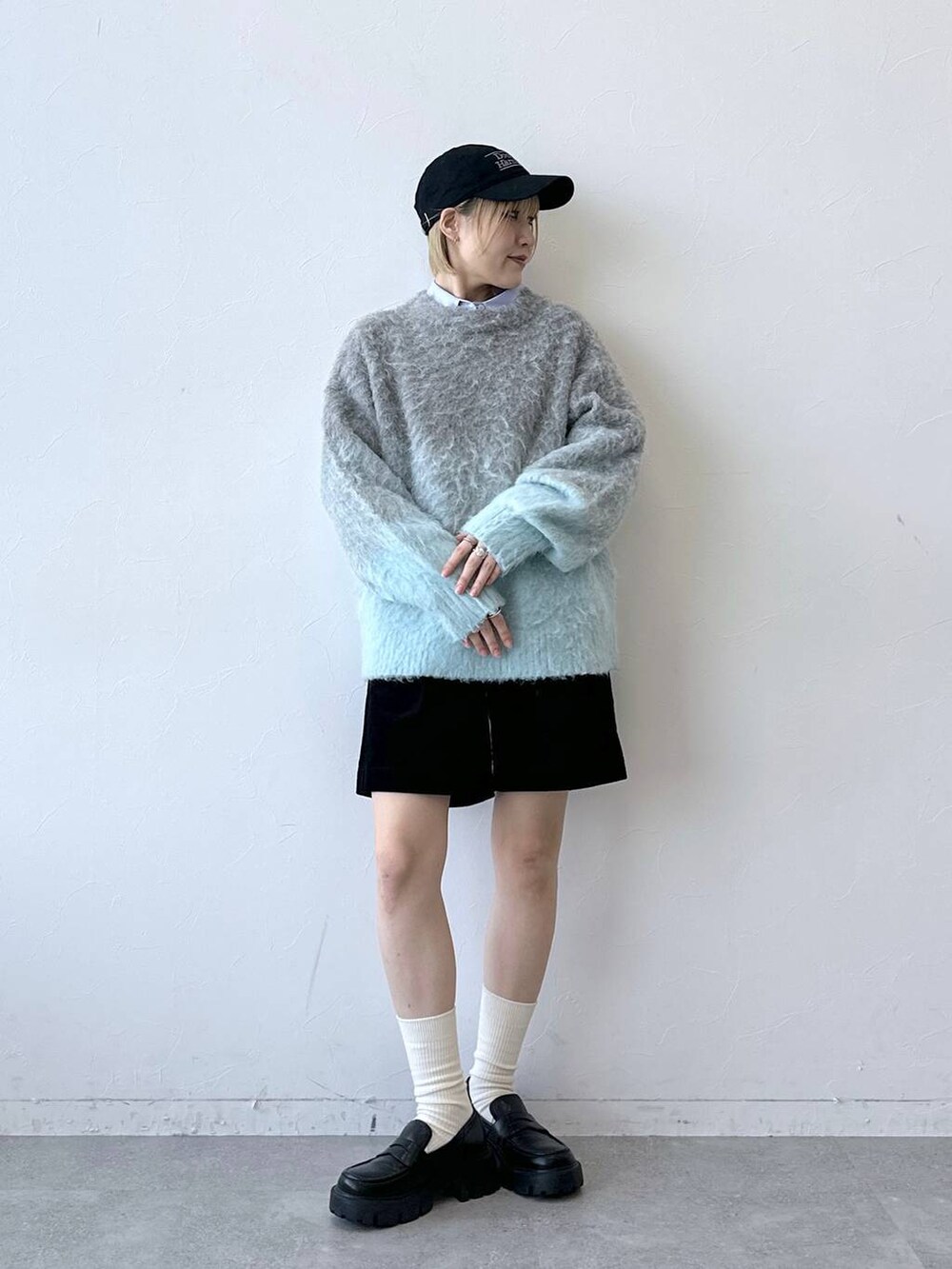 ブラック系のローファー、グレー系のニット/セーター、ブルー系のシャツ/ブラウスを着用したレディースの秋コーディネートの3枚目の写真