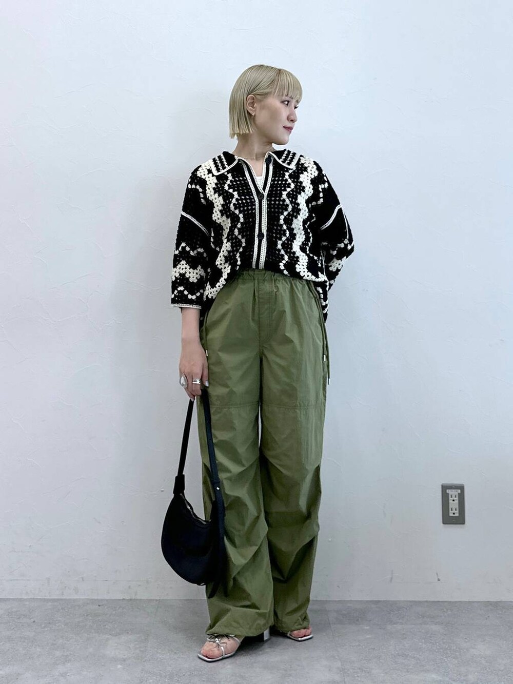 シルバー系のサンダル、ブラック系のカーディガン/ボレロ、グリーン系のカーゴパンツを着用したレディースの夏コーディネートの3枚目の写真