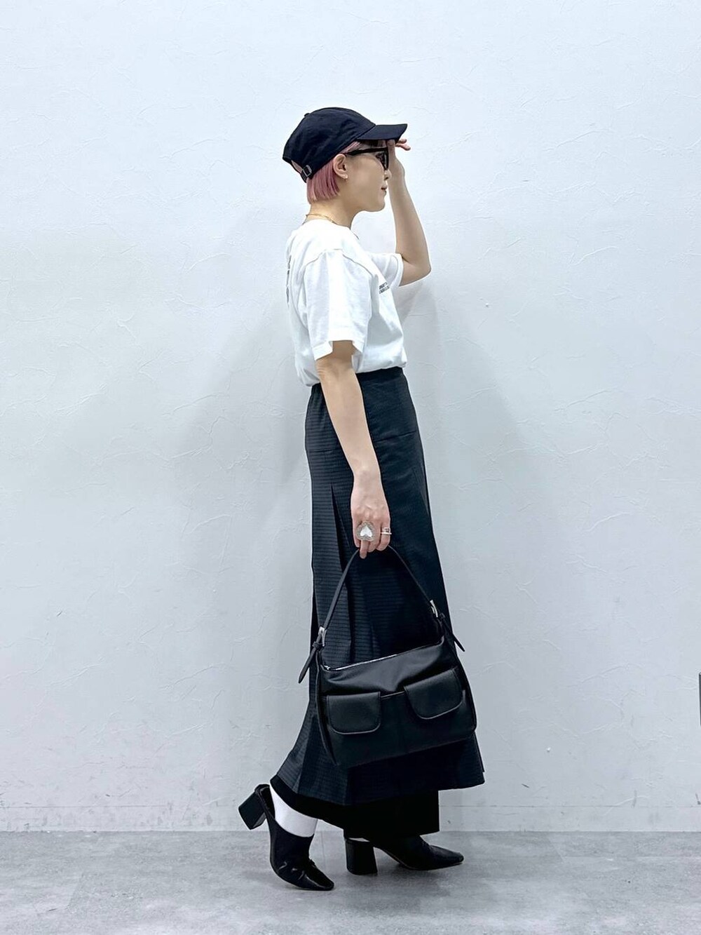 ブラック系のスラックス、グレー系のスカート、ホワイト系のTシャツ/カットソーを着用したレディースの春コーディネートの5枚目の写真