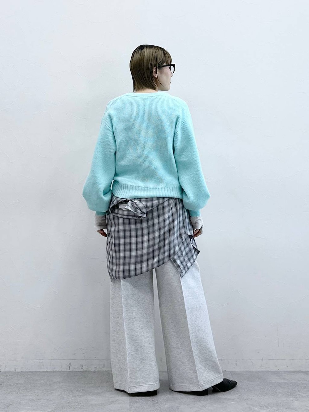 ホワイト系のスウェットパンツ、ブルー系のニット/セーター、ホワイト系のTシャツ/カットソーを着用したレディースの冬コーディネートの6枚目の写真