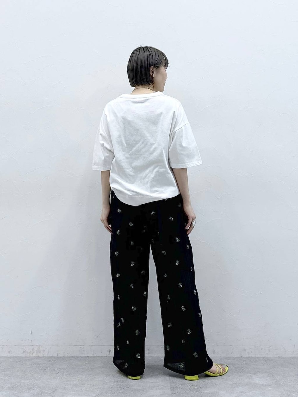 ホワイト系のTシャツ/カットソー、ブラック系のボディバッグ/ウエストポーチ、ブラック系のスラックスを着用したレディースの春コーディネートの5枚目の写真