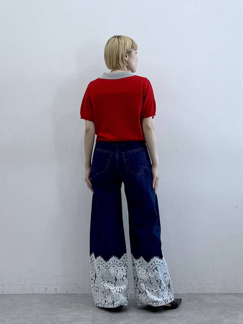 ブルー系のデニムパンツ、レッド系のポロシャツを着用したレディースの春コーディネートの5枚目の写真