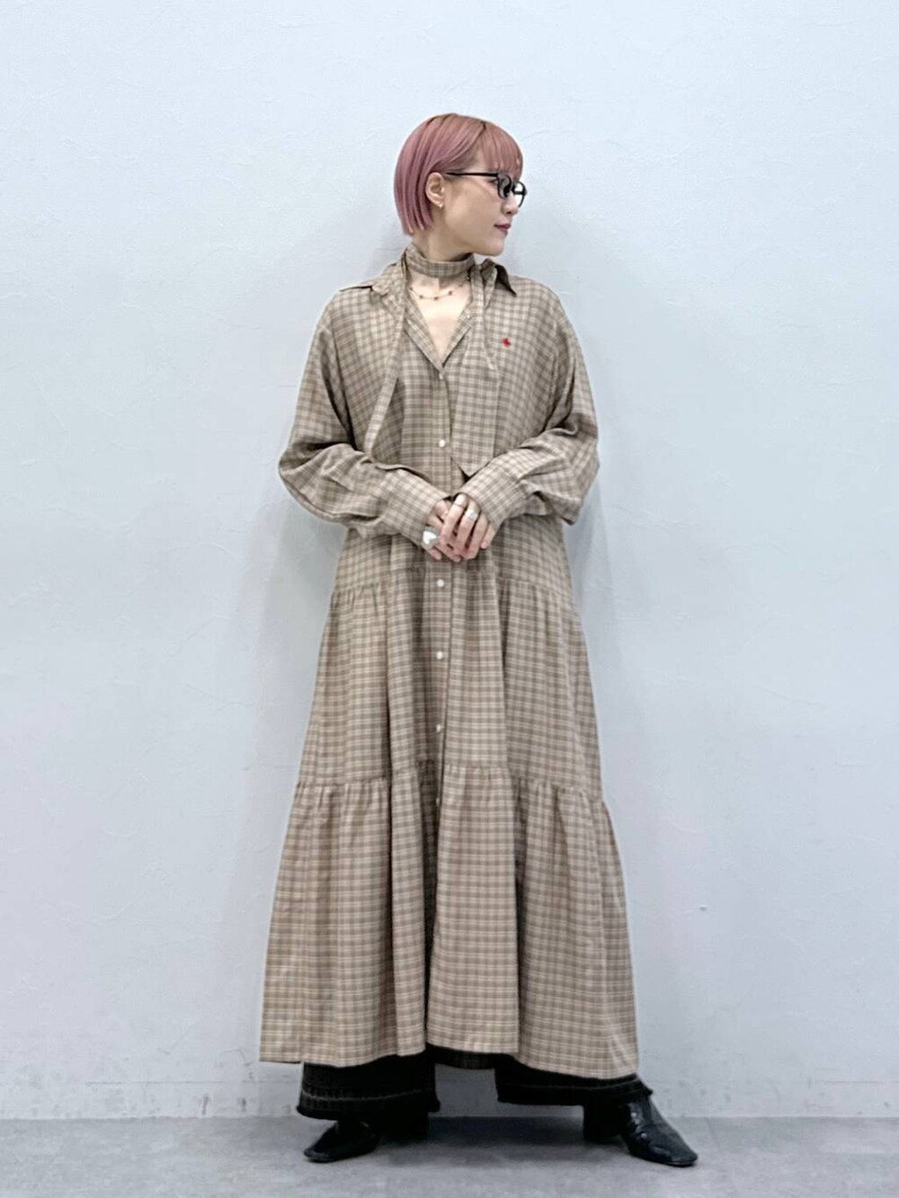 ブラック系のデニムパンツ、ベージュ系のワンピースを着用したレディースの冬コーディネートの2枚目の写真