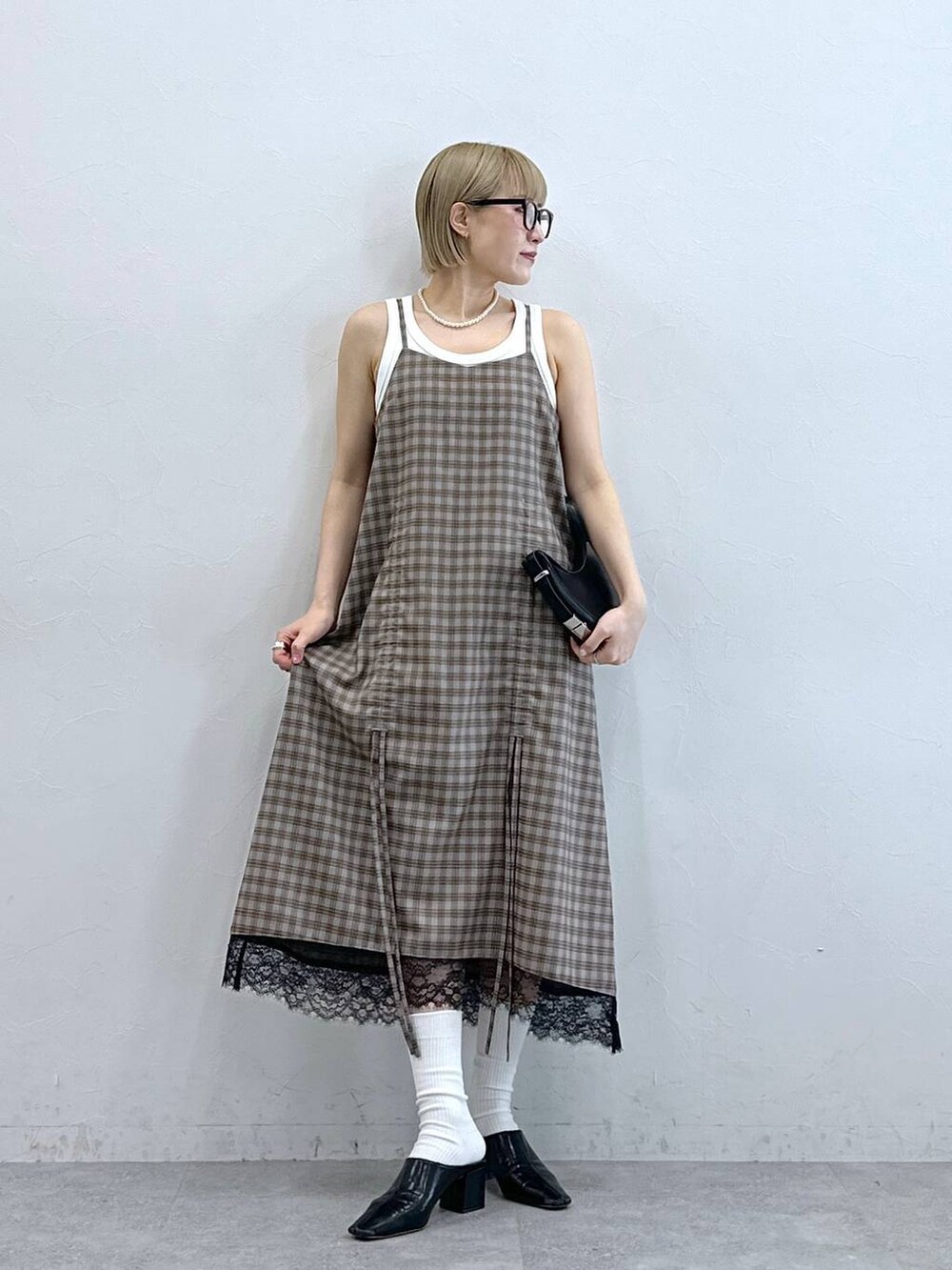 ホワイト系のタンクトップ、グレー系のワンピース、グレー系のメガネを着用したレディースの夏コーディネートの4枚目の写真