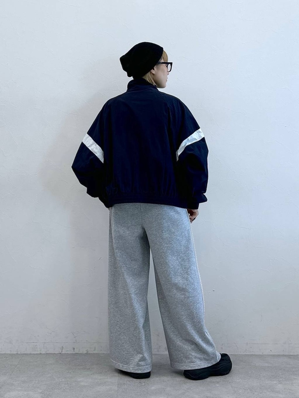 グレー系のスウェットパンツ、ブルー系のブルゾン、ブラック系のニットキャップ/ビーニーを着用したレディースの夏コーディネートの5枚目の写真