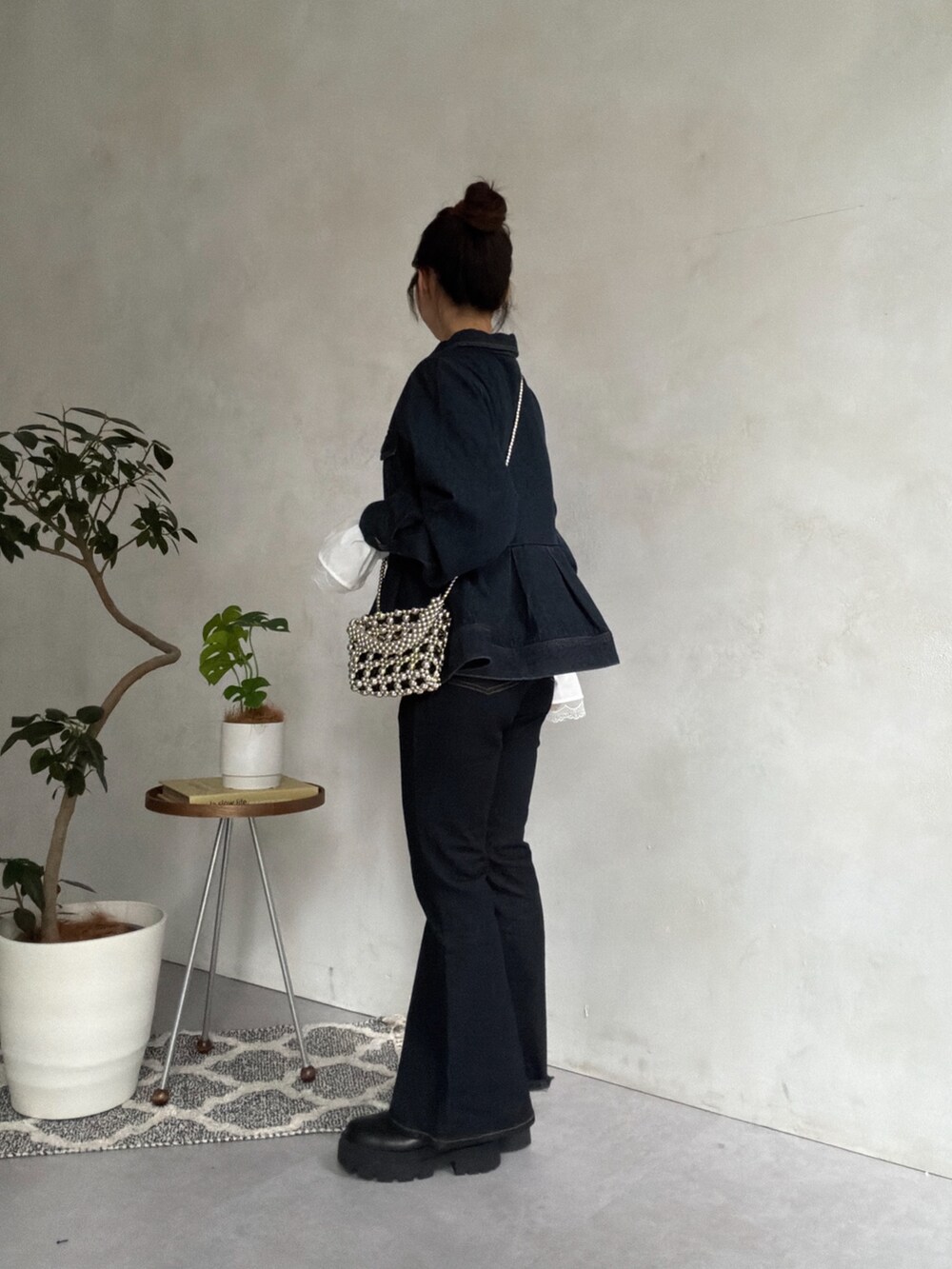 ブルー系のデニムパンツ、ブラック系のブーツ、ブラック系のニット/セーターを着用したレディースの秋コーディネートの2枚目の写真