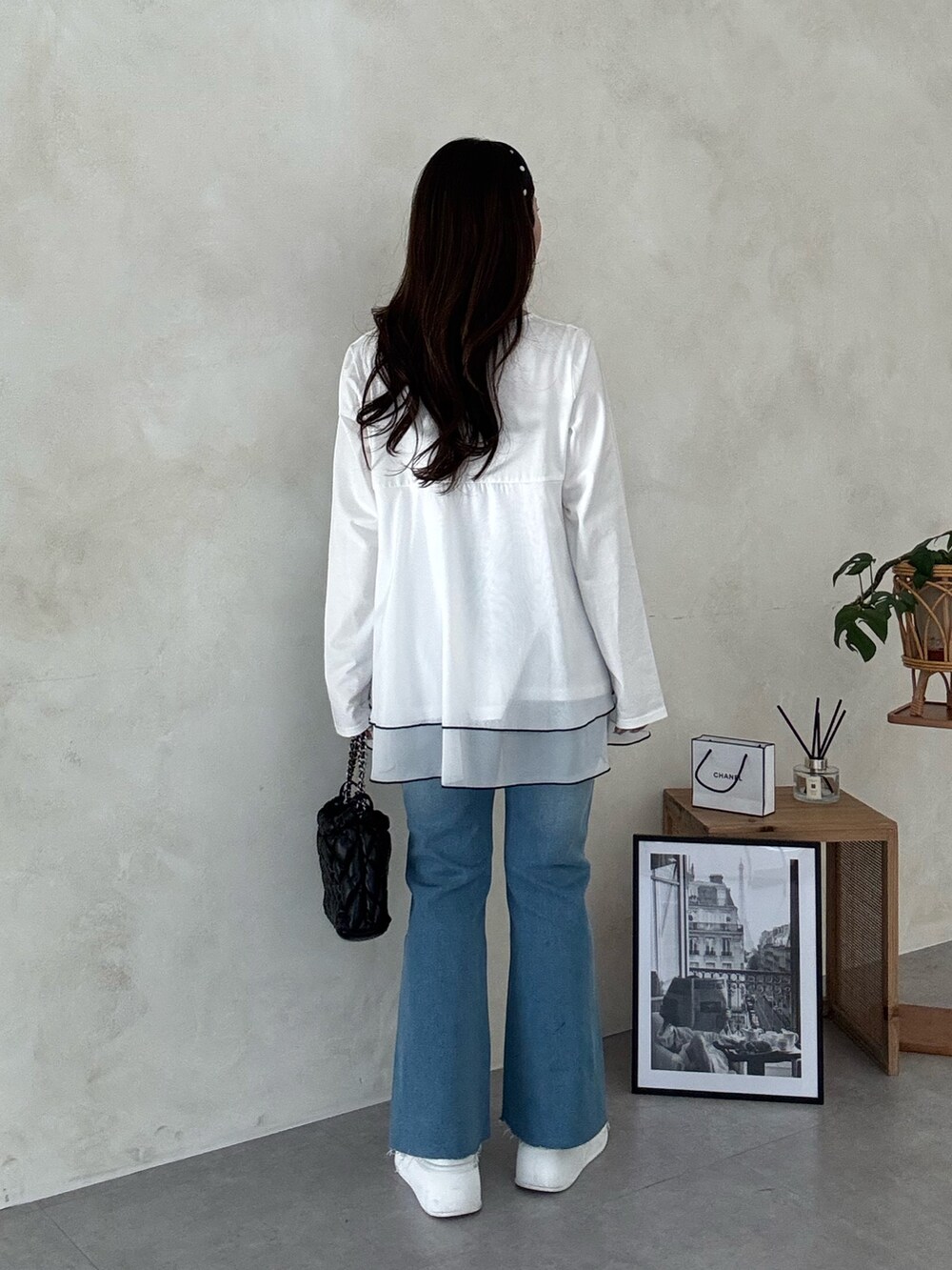 ブラック系のショルダーバッグ、ブルー系のデニムパンツ、ホワイト系のTシャツ/カットソーを着用したレディースの冬コーディネートの3枚目の写真