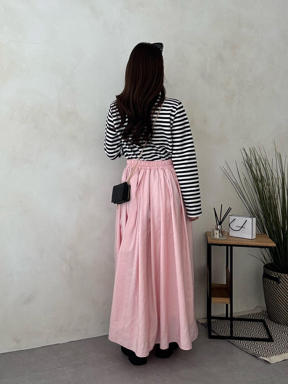 ブラック系のブーツ、ピンク系のスカートを着用したレディースの冬コーディネートの3枚目の写真