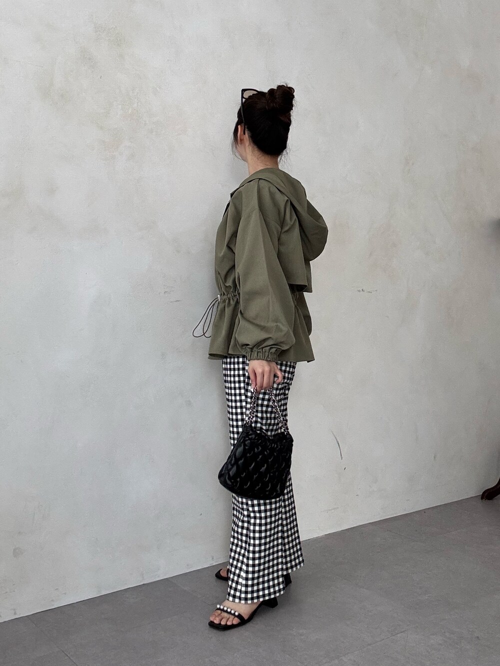 ブラック系のサンダル、ホワイト系のTシャツ/カットソー、グリーン系のブルゾンを着用したレディースの春コーディネートの2枚目の写真