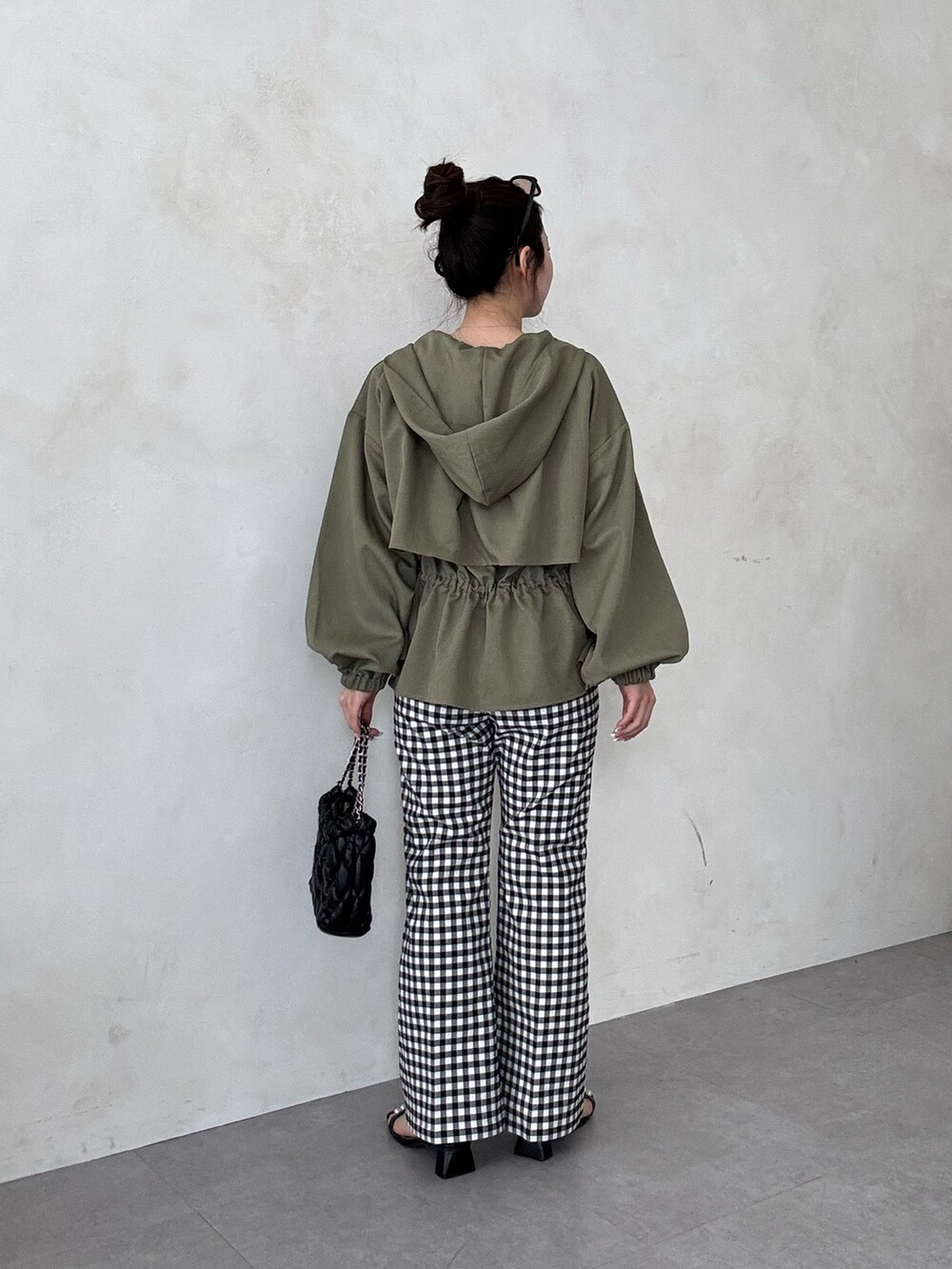 ブラック系のサンダル、ホワイト系のTシャツ/カットソー、グリーン系のブルゾンを着用したレディースの春コーディネートの3枚目の写真